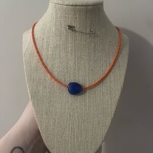 #14. Handmade Orange Beaded Necklace with Blue Pendant
